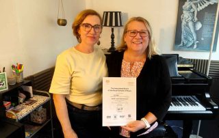 Anna presenting Yvonne with her ABRSM Grade 7 distinction certificate
